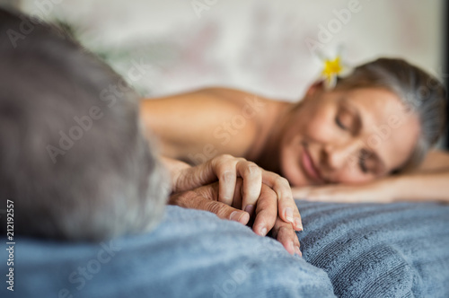 Mature couple holding hands at spa