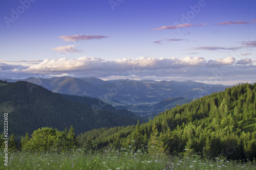 Photo of mountain landscape in the summer under beautiful cloudy sky. Ukraine, Carpathians, Dzembronia village.