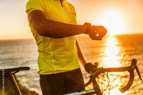 Smartwatch biking cyclist athlete using smart watch activity tracker gps during cycling training. Road bike sports man using his watch app for fitness tracking. Healthy lifestyle.