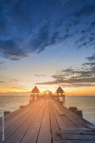 Wooden walking path with sunset over ocean skyline background