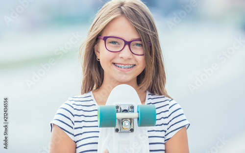 Portrait of happy smiling girl with dental braces and glasses