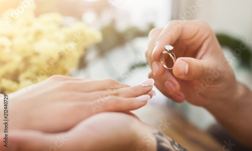 Man putting on girl finger engagement ring