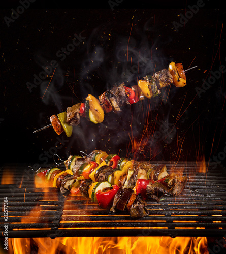 Tasty skewers on the grill with flames