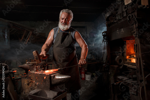 Blacksmith with brush handles the molten metal