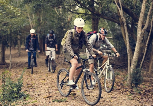 Group of friends ride mountain bike in the forest together