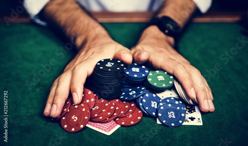 Closeup of hands with gambling tokens and card