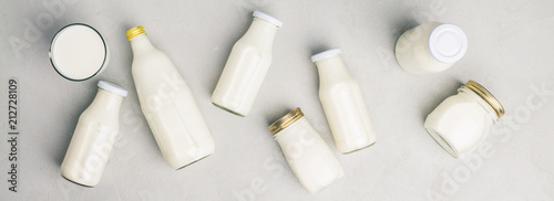 Various bottles of milk on grey concrete background