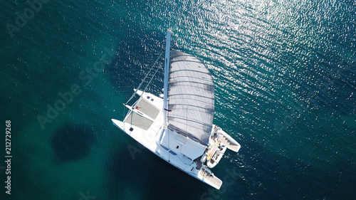 Aerial drone bird's eye view photo from luxury Catamaran docked at tropical deep blue sea