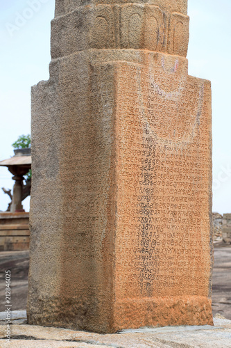 Kannada inscriptions carved on Brahmasthambha, Chandragiri hill, Sravanabelgola, Karnataka. A seated figure of Lord Brahma sits at the top.