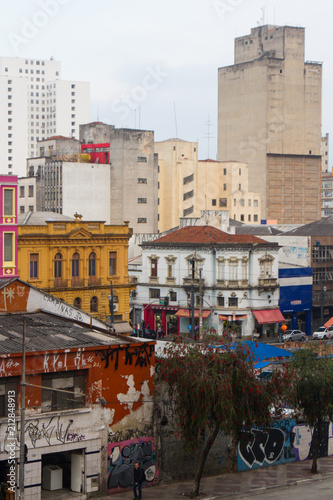Old and aged randomically painted buildings with orange, pink, yellow, white, blue, red and cream colors in a vertical image of downtown.