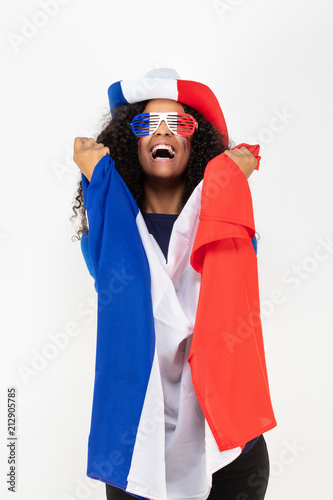 Portrait d'une jeune supportrice de l'équipe de France de football portant un chapeau , des lunettes tricolore et une écharpe de son équipe 
