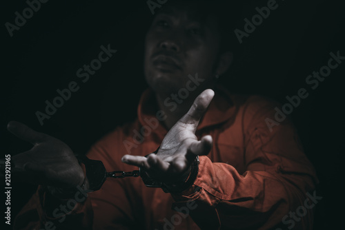 The suspect wear prisoner cloths was arrested at the investigation, interview to find out the truth, the thief was caught by the police come to the dark room,Thailand people,Knife in hand