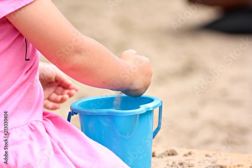 dziewczynka bawi się piaskiem na plaży 