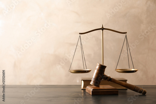 Wooden gavel with scales of justice and book on table. Law concept