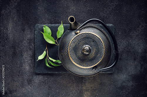 Green tea leaf with black teapot