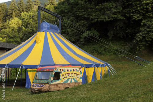 Yellow and blue circus tent near a forest