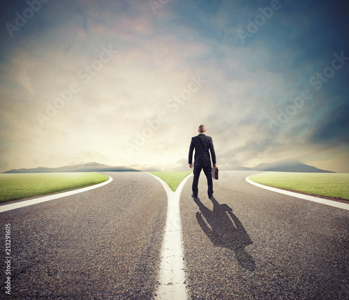 Businessman in front of a crossway must select the right way