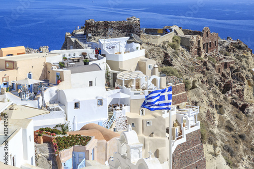 Castillo area with castle and byzantine ruins and greek flag in Oia village, Santorini island, Greece