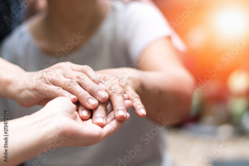 Caregiver, carer hand holding elder hand woman in hospice care. Philanthropy kindness to disabled concept.Public Service Recognition Week