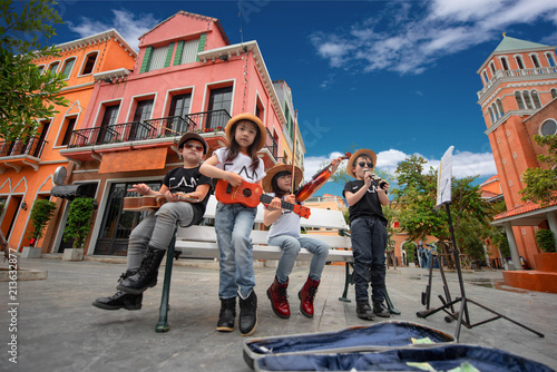 kids playing street musics song on the city walking street for donate, endow, contribute and dole in holidays hobby occasion.