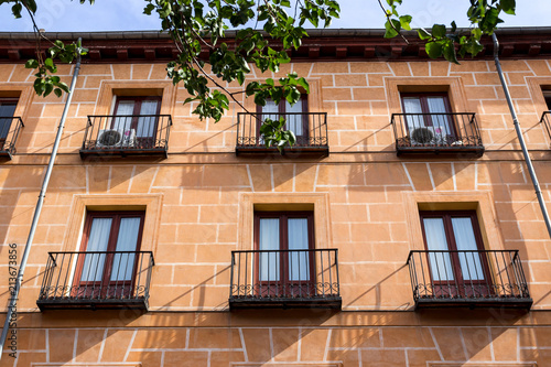 MADRID, SPAIN - MAY 15 2018: Classic Spanish architecture. Living houses in center of the city, balconies and windows covered with marquisa, colorful walls with nice material textures.