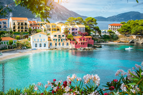 Turquoise colored bay in Mediterranean sea with beautiful colorful houses in Assos village in Kefalonia, Greece