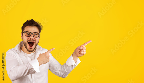 Hipster man pointing away with excitement