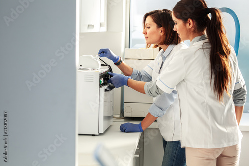 Female dentists in dental office .They cleans equipment for next working day.Using autoclave.