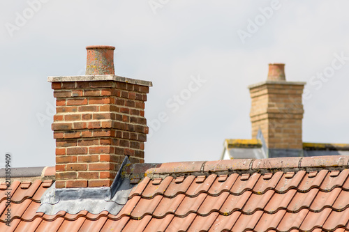 Brick chimney stack on modern contemporary house roof top