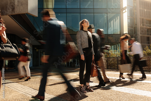 Businesswoman standing still on a busy street