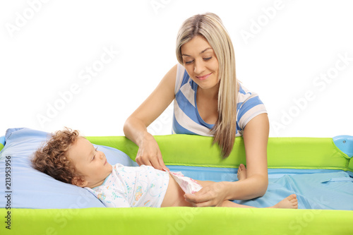 Young mother changing a diaper on her baby son