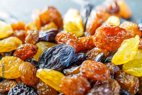 Assortment of Raisins, yellow, blue, black, golden raisin on dark background. Healthy snack, dietary product for good life. Food background and texture, Vega Food. Close-up image. Macro.