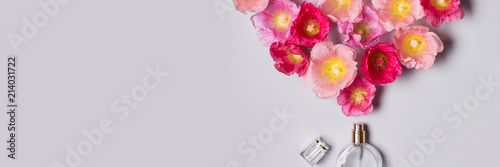 Women's perfume bottle and pink mallow flowers. Minimalism beauty concept