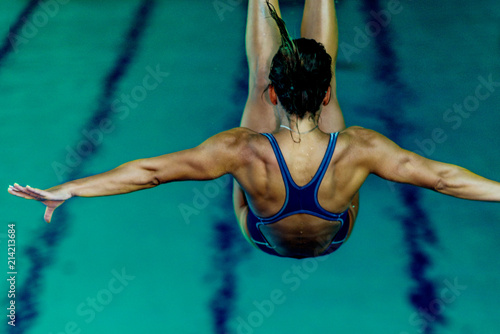 Female diver jumping into the pool