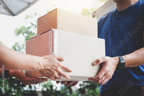 Home delivery service and working service mind, Woman customer hand receiving a cardboard boxes parcel from delivery service courier