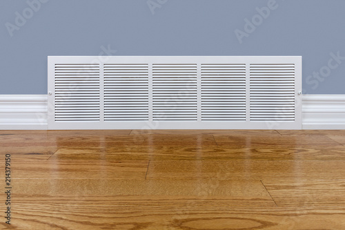 Wall cold air return grille sitting on hardwood floor