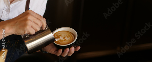 Branner of barista hand making a cup of coffee.