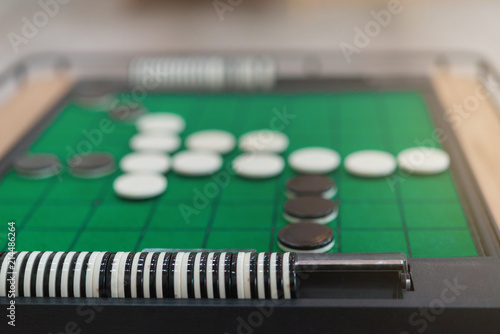 Closeup discs on green Reversi board (Othello),Strategy business concept.