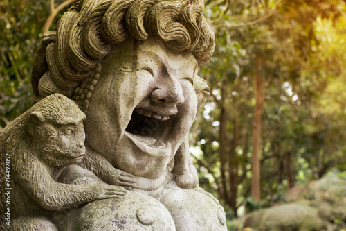 Laughing happy woman sculpture with monkey in Ubud