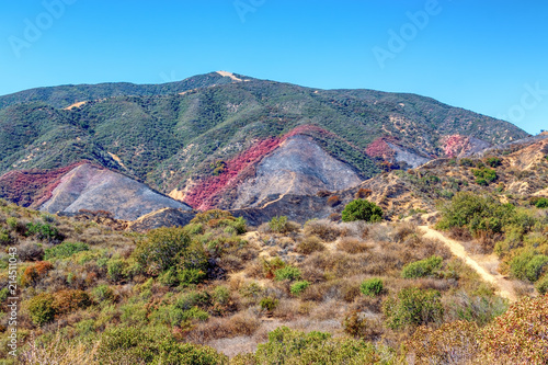 Burned hillsides from forest fire with fire retardant covering hills