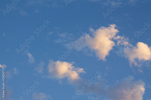 Blue sky with fluffy golden clouds at twilight. Background and textures.