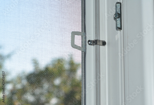 Close up on mosquito wire screen installation on window to protect from insects.