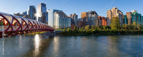 Peace Bridge across Bow River during a vibrant summer sunrise. Taken in Calgary, Alberta, Canada.