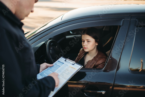 Policeman in uniform writes fine to female driver