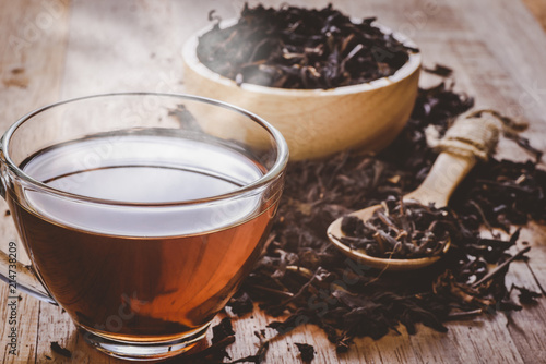 a cup of chinese tea on wooden table, hot drink with steam, vintage tone