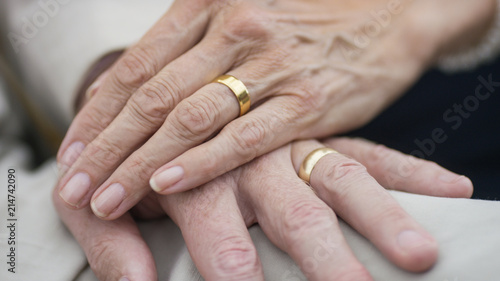Portrait of older senior hands with wedding rings on 