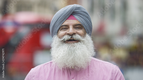 Portrait of senior Indian man in a turban smiling to camera on the street