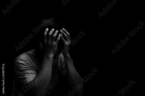 Man sitting alone felling sad worry or fear and hands up on head on black background