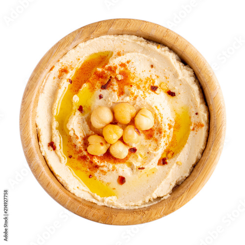 Classic chickpea hummus with olive oil and paprika in wooden bowl isolated on white.