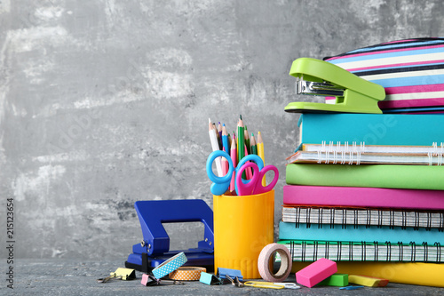 School supplies with books and notebooks on grey background